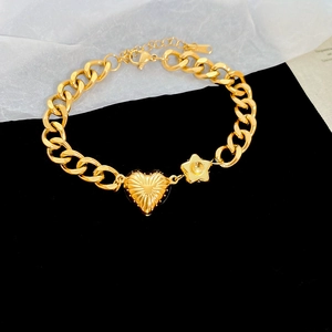 Close-up of gold stainless steel chunky chain bracelet with heart and star pendants