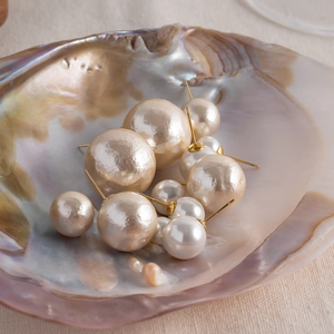 Vue détaillée de perles de coton mates de tailles variées dans un coquillage iridescent