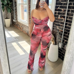 Pink and black marble print halter jumpsuit with flared legs and a draped neckline