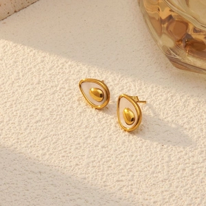 British style avocado shaped gold stud earrings with white inlay on a stone surface