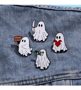 Detail of four Halloween ghost enamel pins featuring a dagger, heart, BOO sign, and bottle