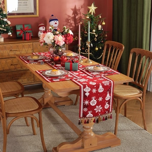 Red Christmas table runner with white snowflake patterns and tassels for dining decor