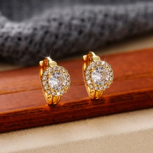 Detailed macro view of gold-plated hoop earring with halo-set round cubic zirconia