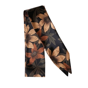 Vintage floral silk skinny scarf in black and brown draped over a plain white background