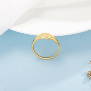 Détail macro d'une bague dorée en acier inoxydable avec motif d'étoile gravé sur le dessus