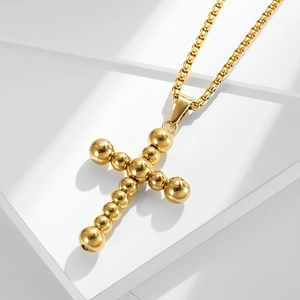 Golden stainless steel necklace featuring a beaded cross pendant on a venetian box chain