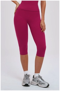 Detail of high-waisted fuchsia yoga leggings showing seamless fabric and compressive fit