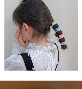 Détail d'élastiques à cheveux macaron pour enfants sur une queue de cheval en tissu doux