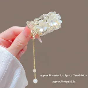 Gros plan d'une pince à cheveux à fleurs et perles avec pompons et détails de taille