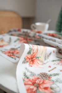 Makroaufnahme einer Samttischdecke mit festlichen Weihnachtsstern- und Beerenmustern