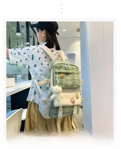 Detail of green plaid school backpack with cute bear pendant and fashion embroidery