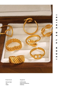 Set of 7 gold heart and snake style rings displayed in a luxury wooden jewelry box