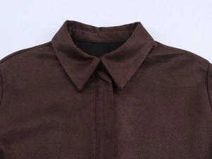 Détail du col d'une chemise en daim marron foncé montrant la texture fine du tissu et couture