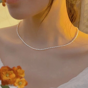 Detail of ultra-fine freshwater pearl necklace in 14K gold plating on a neck model
