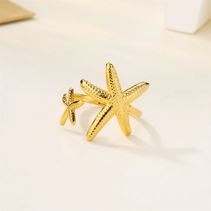 Macro detail of golden starfish ring featuring polished finish and creative sea life design
