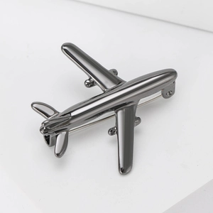 Detailed view of a sleek gun-grey metal airplane brooch with a polished reflective finish