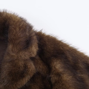 Gros plan détaillé du col en fausse fourrure marron foncé et des fibres synthétiques