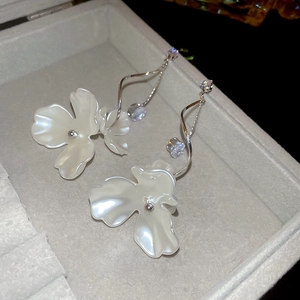 Vue macro de boucles d'oreilles fleur en perles avec détails en zircone et boîte