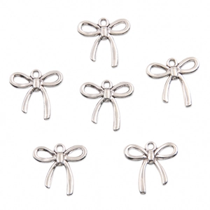 Macro view of six hollow bow-knot alloy pendants in silver finish for DIY jewelry