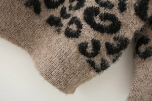 Gros plan d'un cardigan léopard en maille montrant les poignets et la texture douce