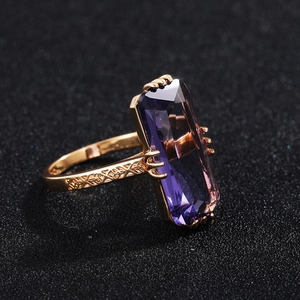Rose gold plated ring featuring a large rectangular purple zircon with intricate engraving