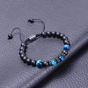 Detail of matte tiger eye beads and blue cat eye stones on a braided adjustable bracelet
