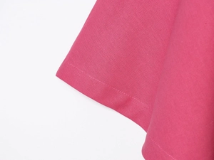 Gros plan du tissu en mélange de lin rose montrant les coutures précises de l'ourlet