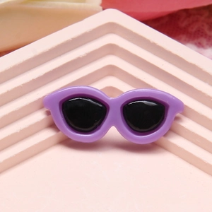 Miniature purple doll sunglasses on a pink geometric display stand for DIY crafts