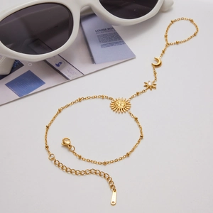 Detail of 18K gold stainless steel hand chain with sun moon and star charms and zircon
