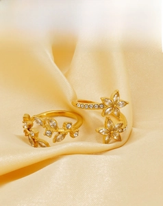 Detail of 18k gold plated stainless steel rings with zircon floral and leaf motifs