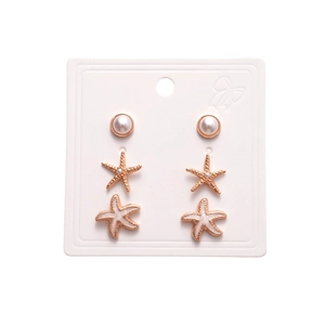 Six-piece gold earring set with faux pearls and white enamel starfish on display card