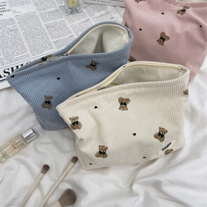 Detailed view of three corduroy makeup bags with cute bear embroidery and metal zippers