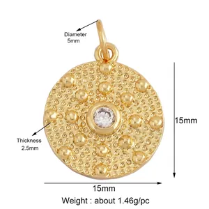 Close-up of 15mm gold pendant with clear zircon center and embossed dot textures