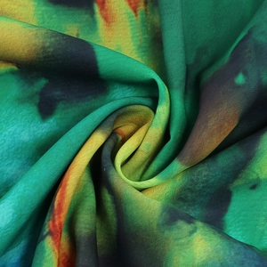 Detailed close-up of colorful abstract tie-dye fabric with smooth spiral texture and flow