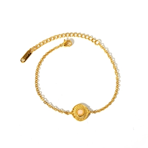 Détail du pendentif soleil en acier doré avec pierre rose et fermoir mousqueton robuste