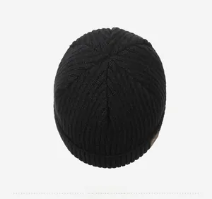 Top view of black ribbed knit beanie showing thick warm texture and brown leather label