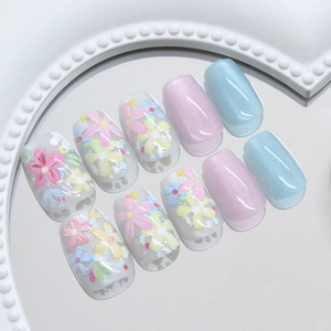 Floral cat-eye press-on nails with pastel macaron colors on a white pearl mirror