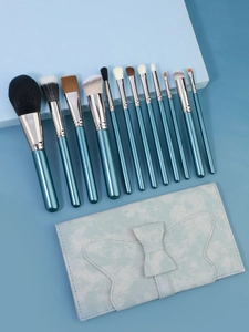 Dettaglio del set di 12 pennelli da trucco con manici blu pavone e custodia a farfalla