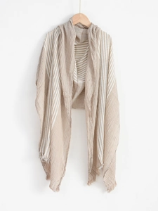 Detailed view of the beige and white striped scarf texture with soft frayed edges