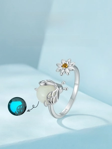Macro detail of S925 sterling silver ring showing glowing firefly and daisy design