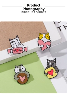 Detailed view of four cute enamel cat pins with heart motifs and polished alloy finish