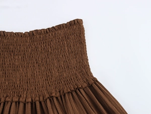 Detailed view of dark brown smocked elastic high waist with elegant ruffle trim design