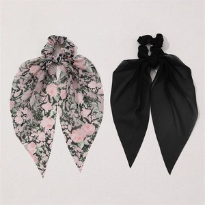 Detail of floral and solid black chiffon scrunchies with elegant long ribbon tails