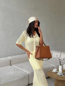Detailed knit texture of a yellow two-piece crochet skirt set shown in indoor setting