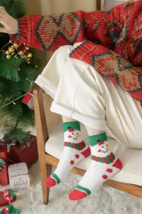 Detailed view of plush coral fleece Christmas socks featuring a cute snowman pattern