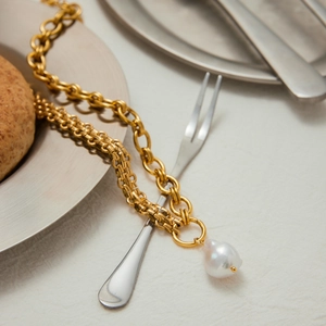 Detail of gold-plated stainless steel chain necklace with an irregular white pearl pendant