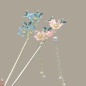Detail view of Chinese hairpins with resin flowers, metal tassels and white pearls