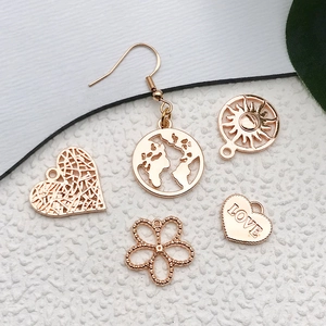 Flat lay of vintage gold DIY alloy charms including sun, map, and heart shapes