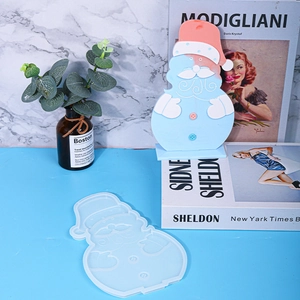 Christmas Santa Claus silicone mold and finished resin craft on a blue surface