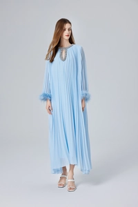 Détail de robe maxi plissée bleu clair avec perles au col et poignets en plumes
